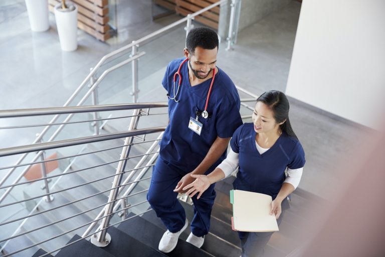 Two healthcare colleagues talking on the stairs at hospital